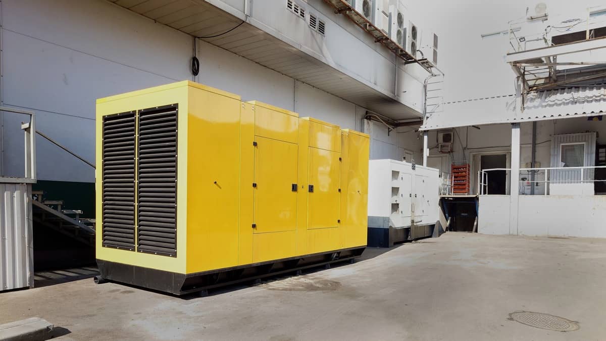 En stor gul generator på en industriplads