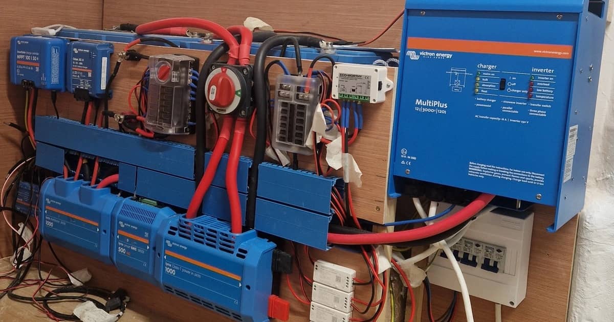 Victron inverter/oplader, solcelleregulatorer og strømskinner monteret på en autocamper-væg